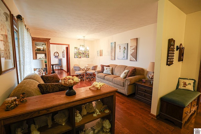 living room featuring a textured ceiling, a chandelier, and dark hardwood / wood-style floors