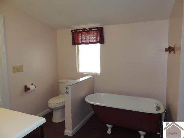 bathroom featuring a tub, vanity, and toilet