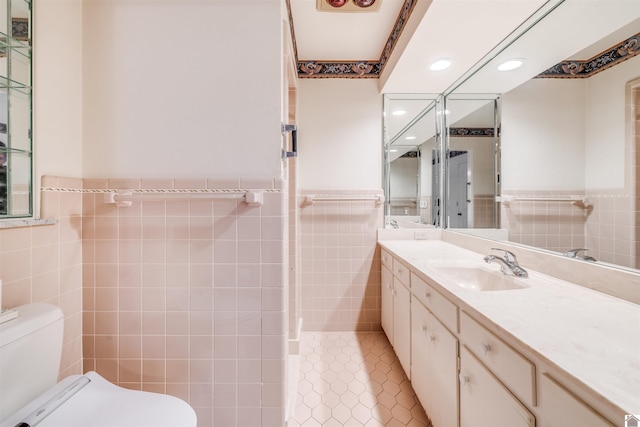 bathroom with vanity, toilet, and tile walls