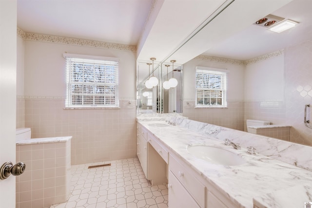 bathroom featuring vanity, tile walls, and a healthy amount of sunlight