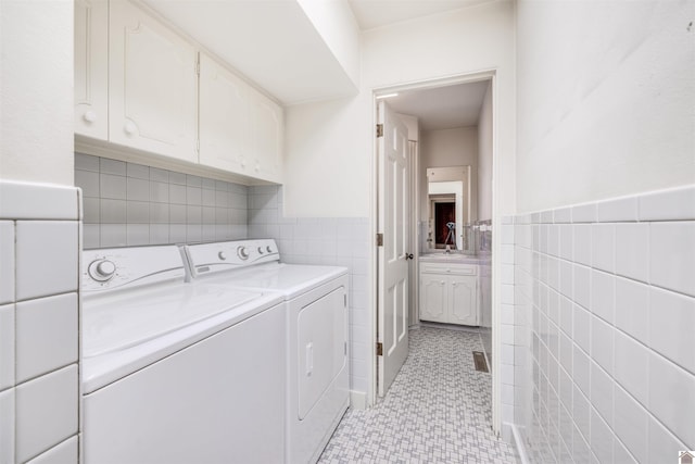 laundry area with washer and dryer and tile walls