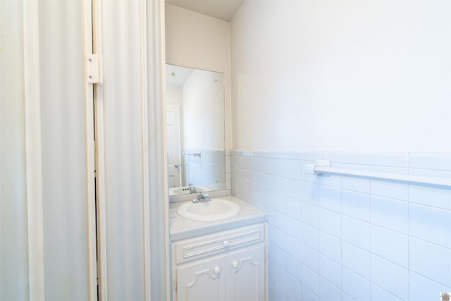 bathroom featuring vanity and tile walls