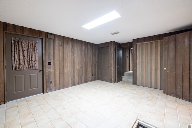 basement featuring wooden walls