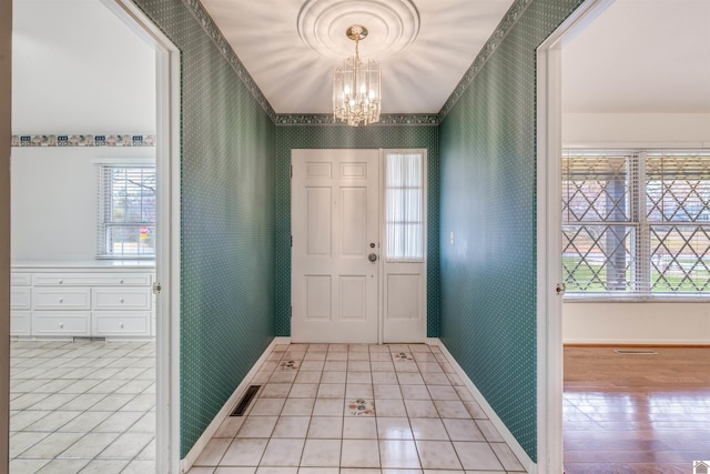 foyer with an inviting chandelier and light wood-type flooring