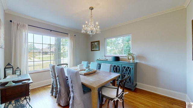 dining area with a wealth of natural light, ornamental molding, light hardwood / wood-style floors, and a notable chandelier