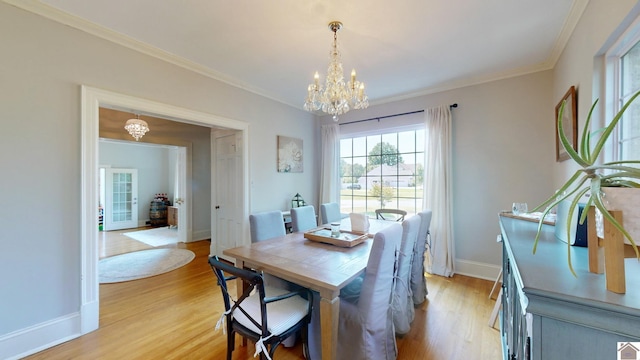 dining room featuring ornamental molding, a chandelier, and light wood-type flooring