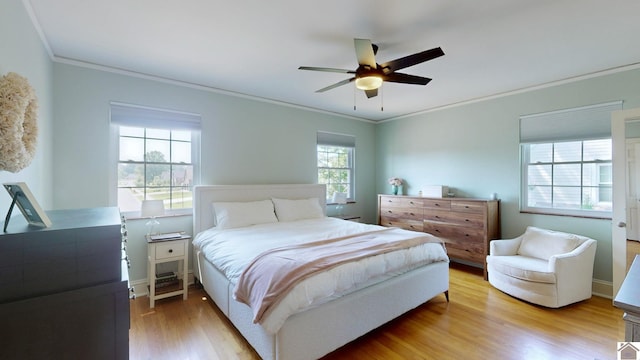 bedroom with light wood-type flooring, ceiling fan, and ornamental molding