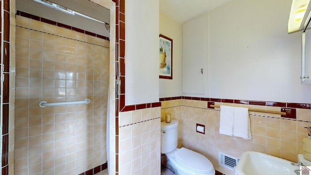 bathroom with toilet and tile walls