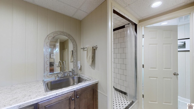 bathroom with vanity, walk in shower, and wooden walls