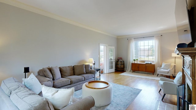 living room with light hardwood / wood-style floors, ornamental molding, and a fireplace