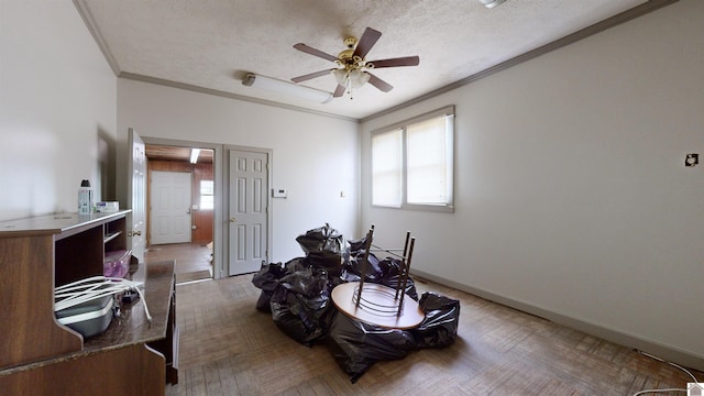 miscellaneous room featuring ceiling fan, ornamental molding, a textured ceiling, and parquet floors