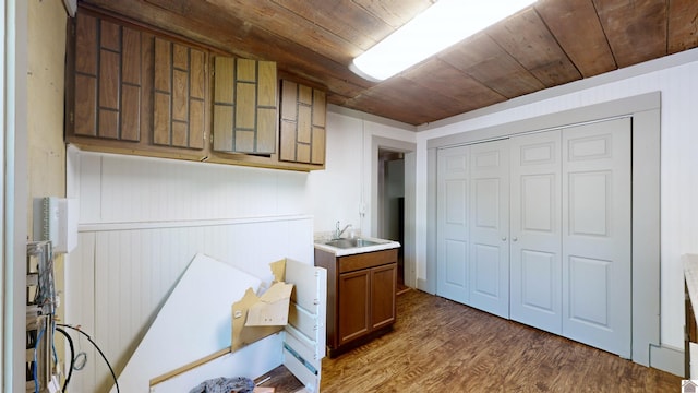 clothes washing area with dark hardwood / wood-style flooring, wood walls, sink, and wood ceiling