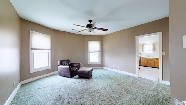 sitting room with light carpet, sink, plenty of natural light, and ceiling fan