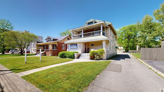 view of front facade featuring a porch, a balcony, and a front yard