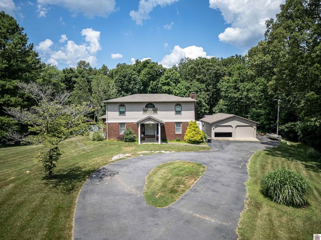 view of front facade featuring an outbuilding, a front yard, and a garage