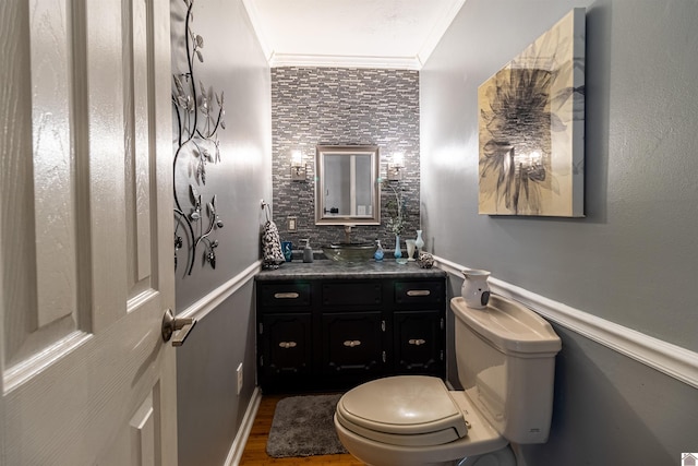 bathroom with toilet, vanity, hardwood / wood-style floors, and ornamental molding