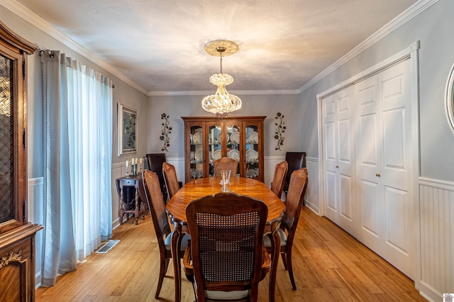 dining space featuring light hardwood / wood-style flooring, plenty of natural light, and ornamental molding