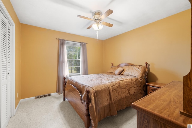 carpeted bedroom with ceiling fan and a closet