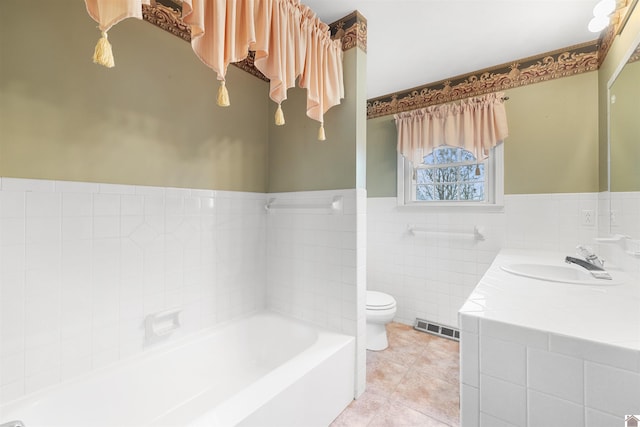 bathroom featuring vanity, tile patterned floors, a bathing tub, toilet, and tile walls