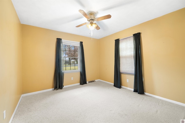 carpeted spare room featuring ceiling fan