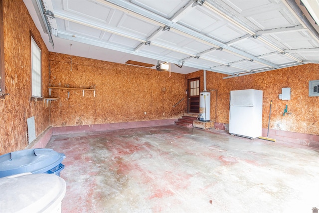 garage with white refrigerator, a garage door opener, and water heater