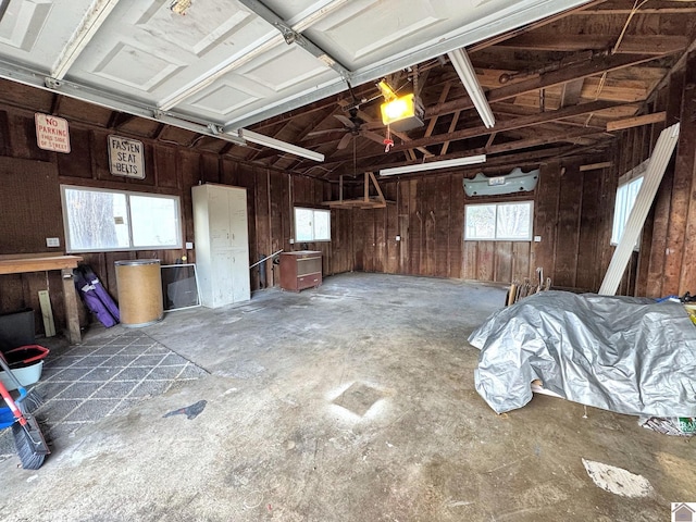 garage featuring a garage door opener and wood walls