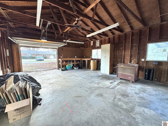 garage featuring a garage door opener and wooden walls