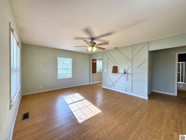 empty room with ceiling fan and light wood-type flooring