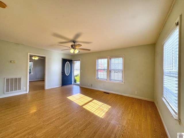 spare room with ceiling fan and light wood-type flooring