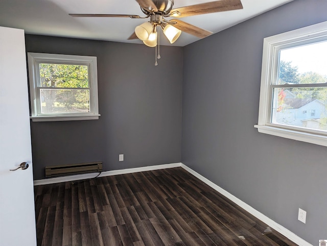 spare room with baseboard heating, ceiling fan, and dark wood-type flooring