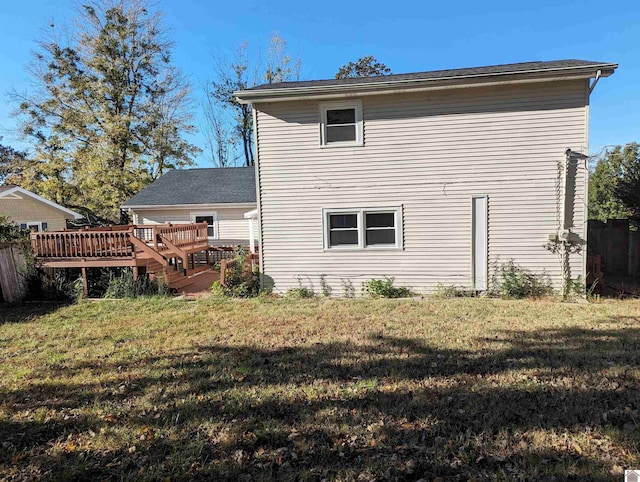 back of property with a lawn and a wooden deck