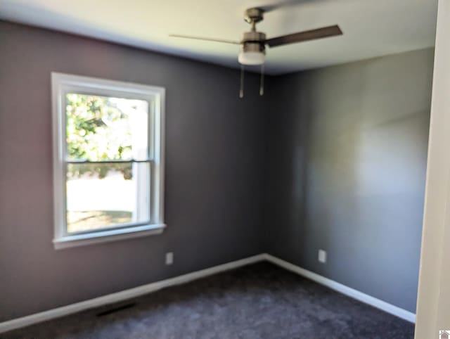 unfurnished room with dark colored carpet