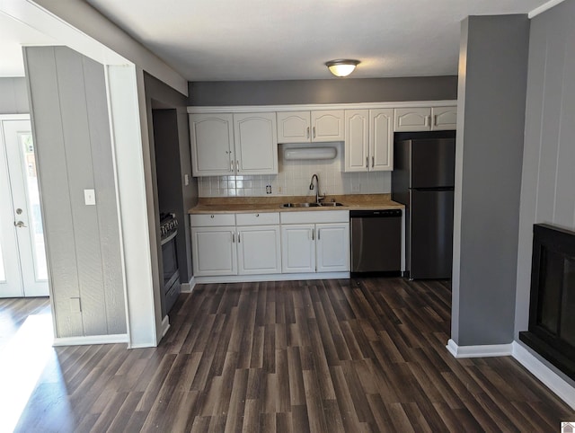 kitchen featuring backsplash, stainless steel appliances, sink, dark hardwood / wood-style floors, and white cabinetry