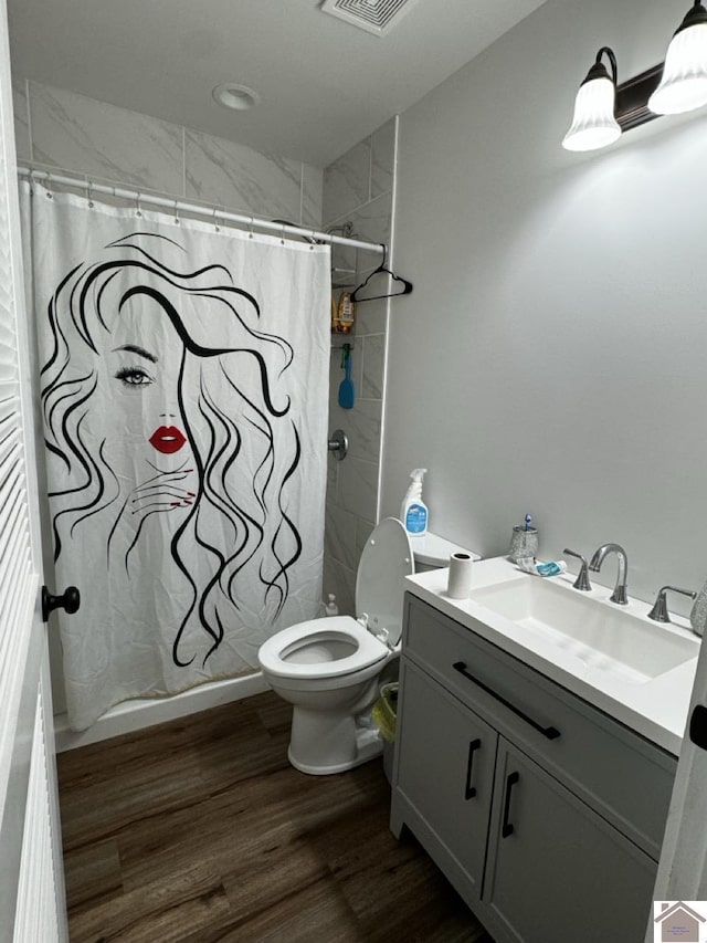 bathroom with curtained shower, toilet, vanity, and hardwood / wood-style flooring