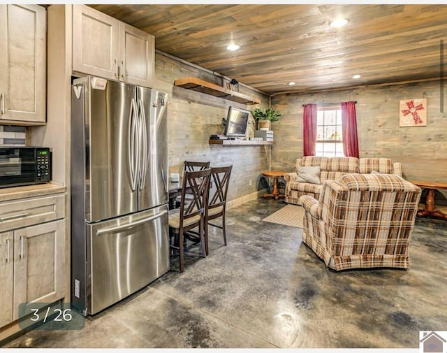 kitchen with stainless steel fridge, wood walls, light brown cabinetry, and wood ceiling