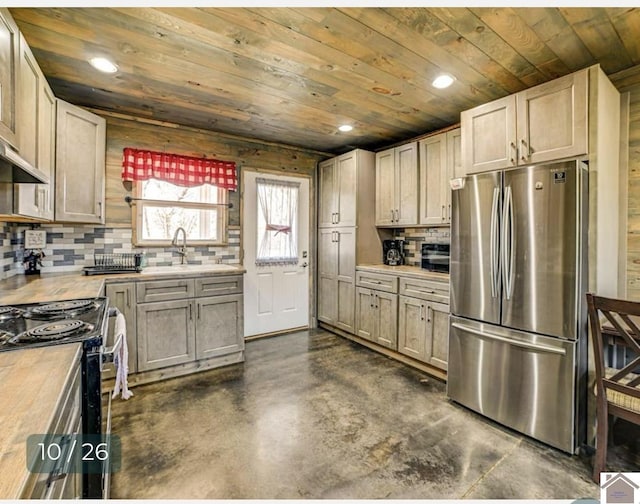 kitchen featuring stainless steel refrigerator, electric range, sink, tasteful backsplash, and wood ceiling