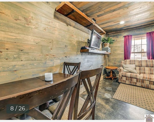 dining space with wooden ceiling and wooden walls