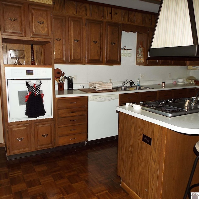 kitchen with white appliances, premium range hood, dark parquet floors, and sink