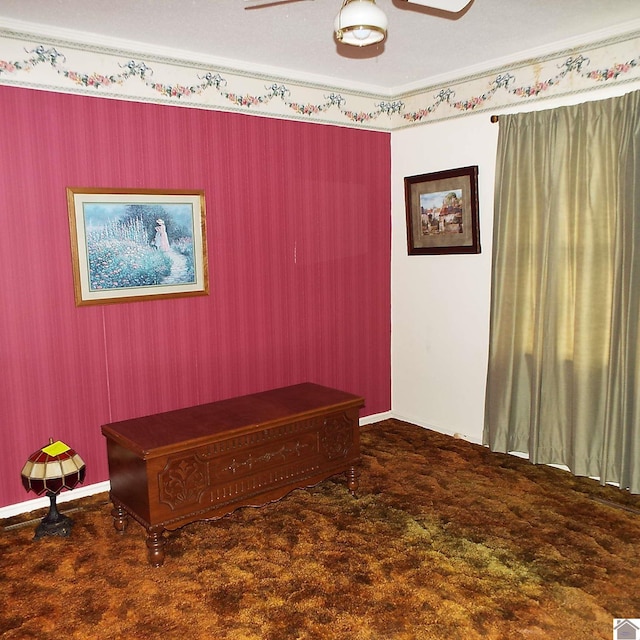 interior space with dark colored carpet, ceiling fan, and crown molding