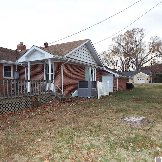 view of side of property featuring a yard and central AC unit