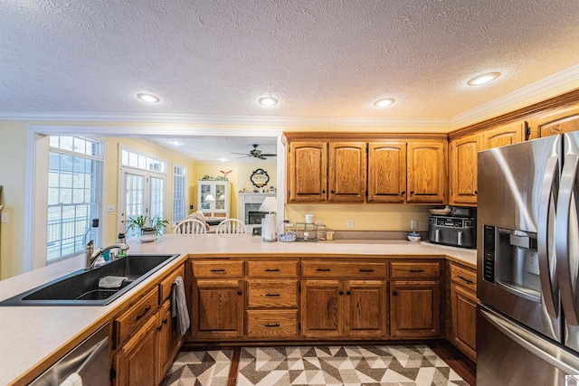 kitchen with crown molding, sink, ceiling fan, appliances with stainless steel finishes, and kitchen peninsula