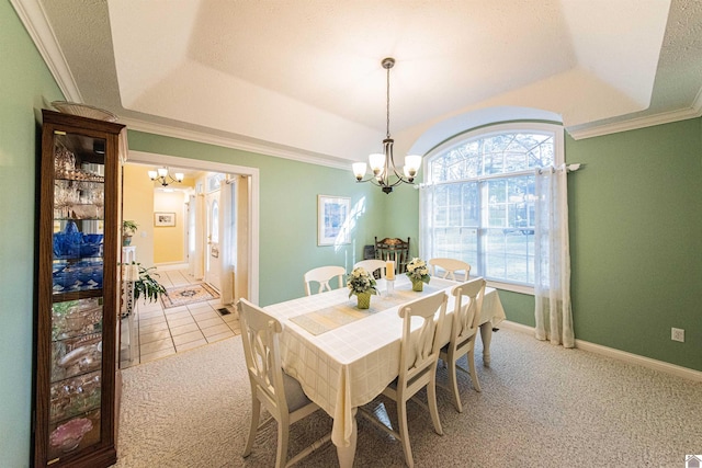 dining space featuring carpet flooring, ornamental molding, a tray ceiling, and an inviting chandelier