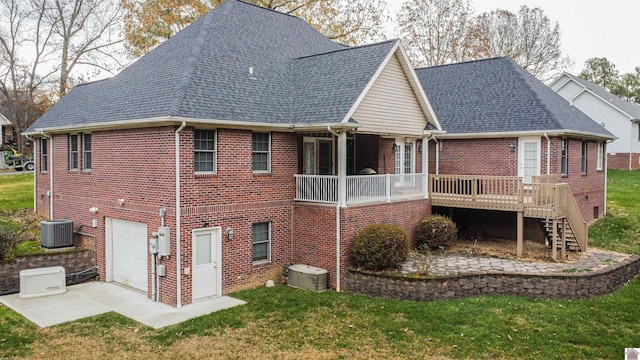 back of property featuring central AC, a garage, a lawn, and a wooden deck