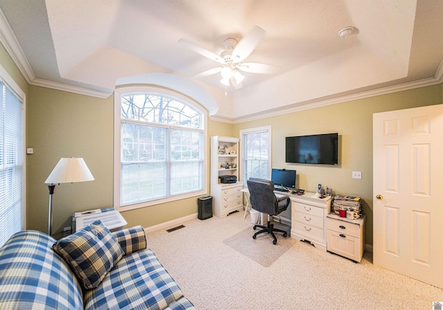 home office featuring ceiling fan, ornamental molding, light carpet, and a tray ceiling