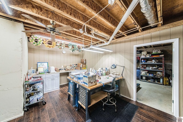 basement featuring a workshop area, ceiling fan, and dark wood-type flooring