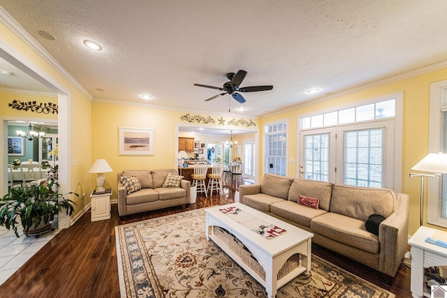 living room featuring crown molding, hardwood / wood-style floors, ceiling fan with notable chandelier, and a textured ceiling