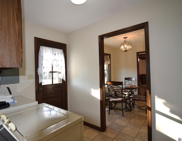 washroom with separate washer and dryer, light tile patterned floors, and a chandelier