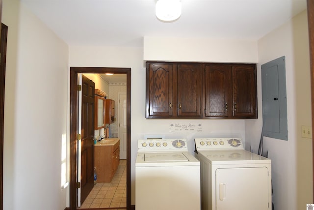 washroom with cabinets, sink, washing machine and dryer, electric panel, and light tile patterned flooring