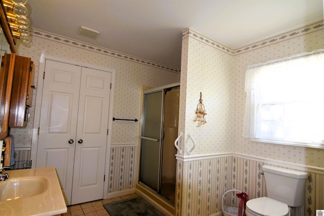 bathroom with plenty of natural light, tile patterned flooring, an enclosed shower, and toilet