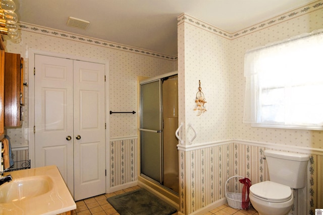 bathroom with tile patterned floors, sink, a shower with door, and toilet